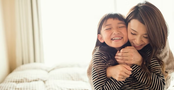 A parent and child sharing a happy moment at home